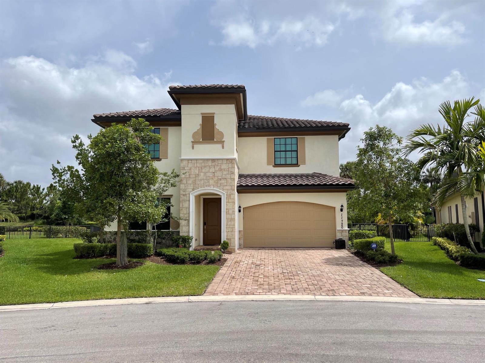 A two-story house with a tile roof, stone facade, and a paved driveway — 11720 Waterway Circle, Parkland FL 33076, PARKLAND, FL
