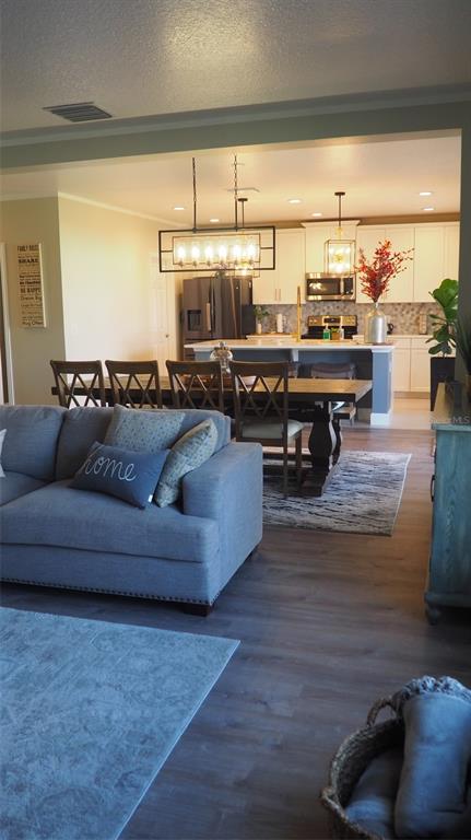 An open-concept living room flows into a dining area and a modern kitchen with island — 216 DENALI STREET, HAINES CITY, FL