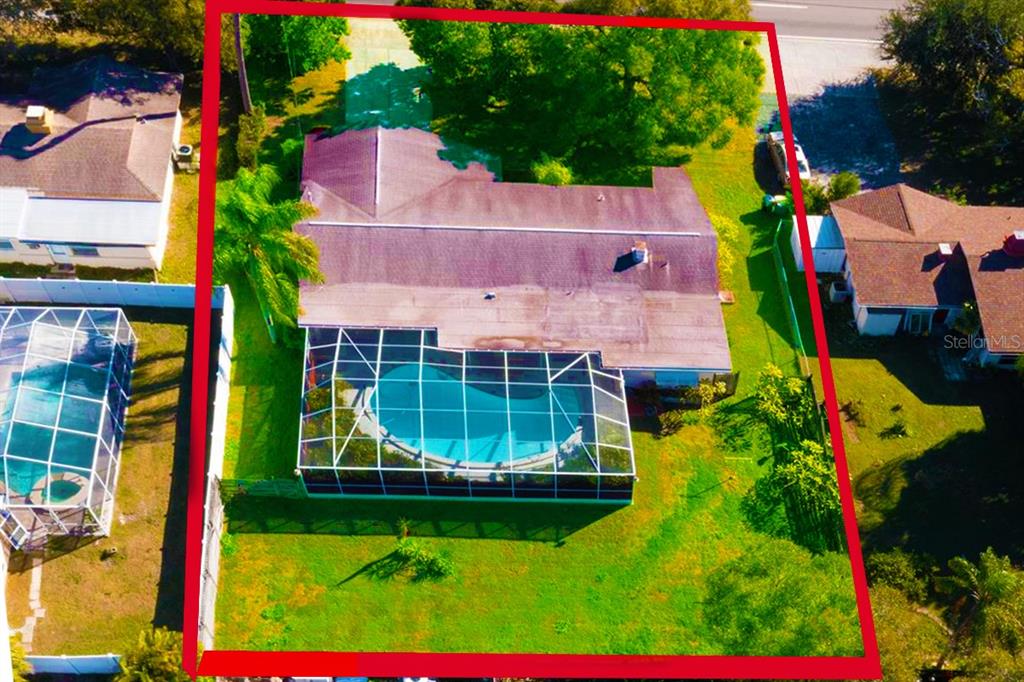 An aerial view shows a house with a screened-in pool and a large backyard — 805 S KEENE ROAD, CLEARWATER, FL