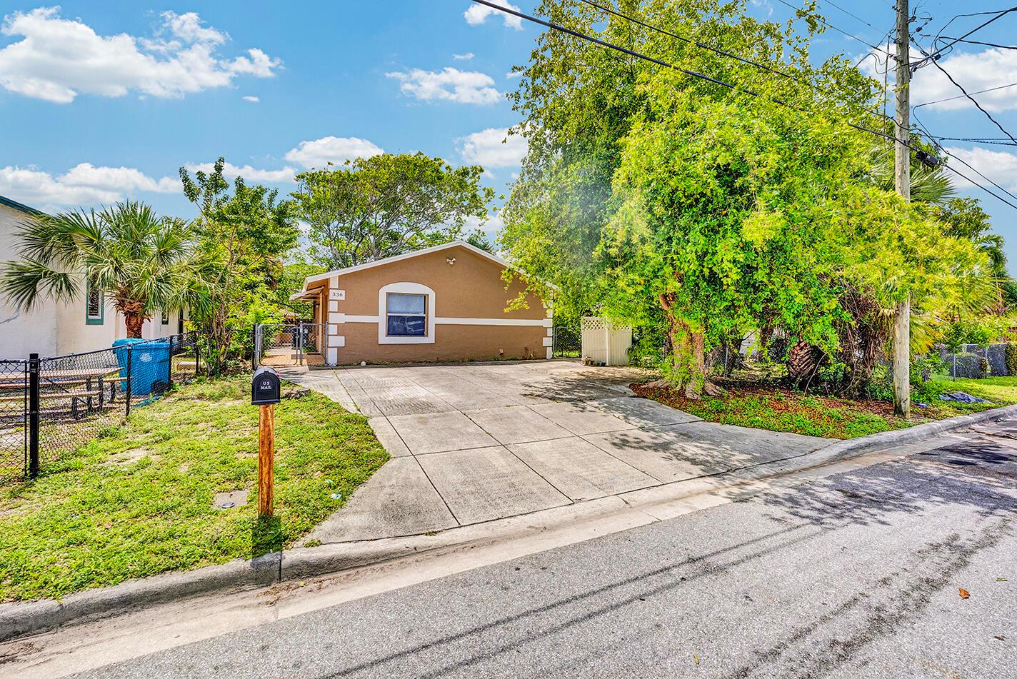A tan, single-story house with a concrete driveway and a large tree in the front yard — 336 NE 12th Avenue, Boynton Beach FL 33435, BOYNTON BEACH, FL