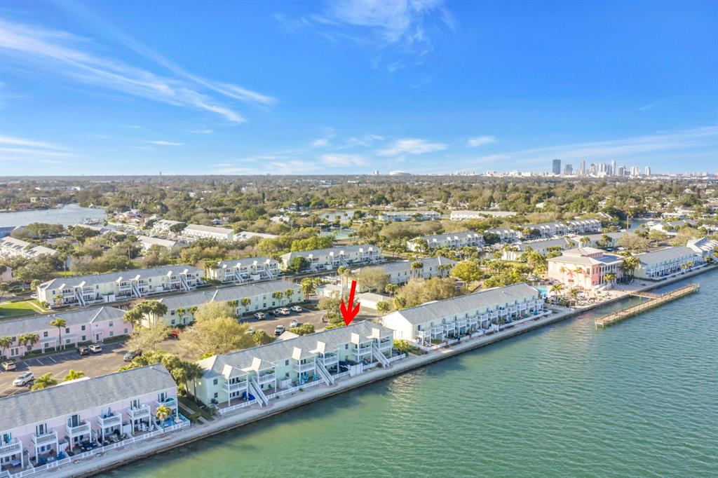 An aerial view shows a row of waterfront townhouses with a red arrow pointing down — 5102 COQUINA KEY DRIVE SE UNIT D, ST PETERSBURG, FL