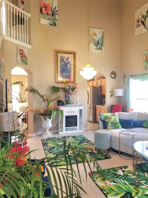 A living room with high ceilings, a fireplace, tropical decor, and a white sectional sofa — 12900 WINFIELD SCOTT BOULEVARD, ORLANDO, FL
