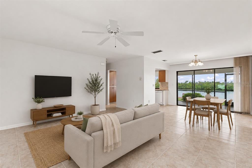 A living and dining area with tile floors, a ceiling fan, and a water view — 18422 ARAPAHOE CIRCLE, PORT CHARLOTTE, FL