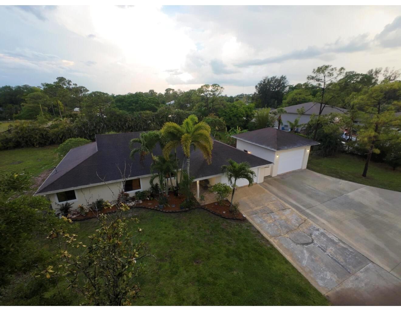 An aerial view of a single-story house with a detached garage and a concrete driveway — 8264 Palomino Drive, Lake Worth FL 33467, LAKE WORTH, FL