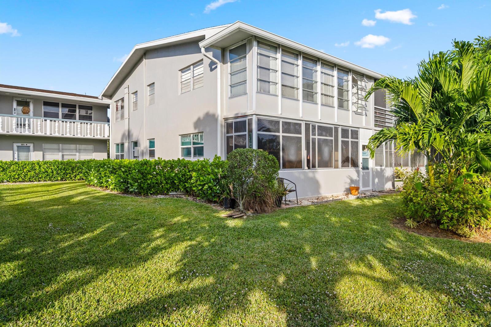 A two-story apartment building with a screened-in ground floor patio and a grassy lawn — 380 Sheffield P, West Palm Beach FL 33417, WEST PALM BEACH, FL
