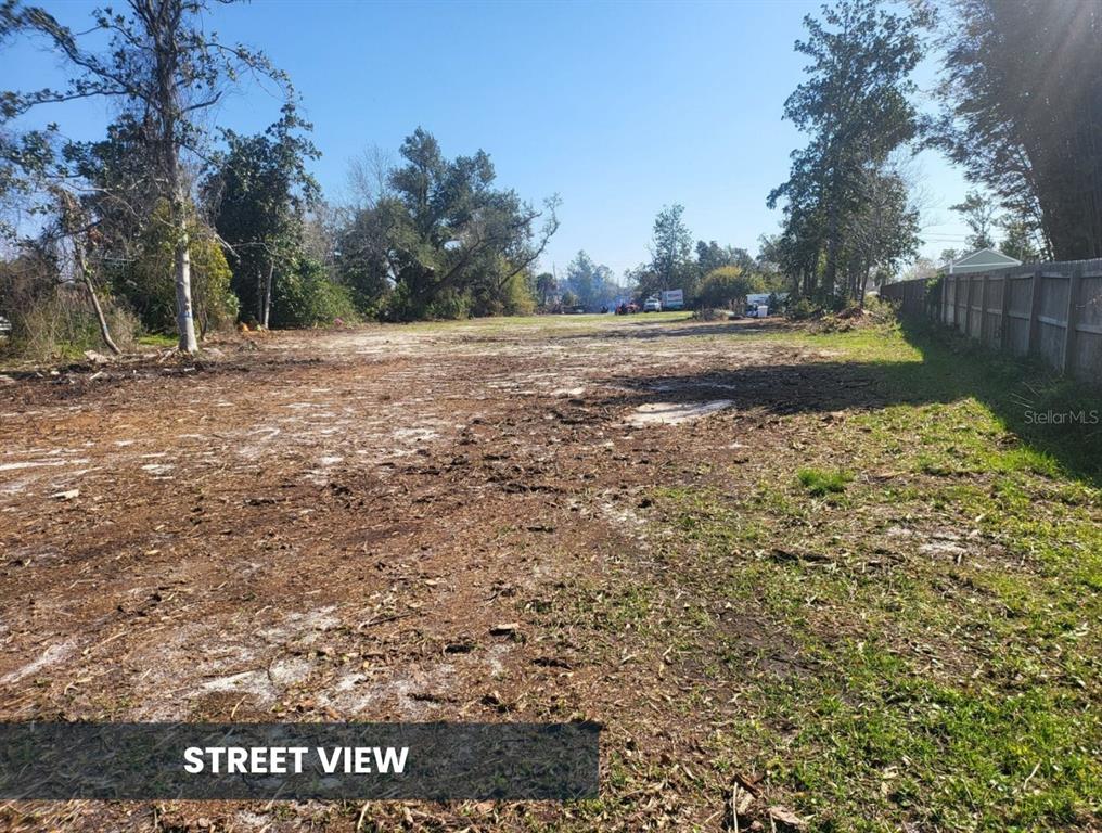 A cleared, flat, vacant lot with scattered debris and trees under a clear blue sky — TBD PLANTATION DRIVE, PANAMA CITY, FL