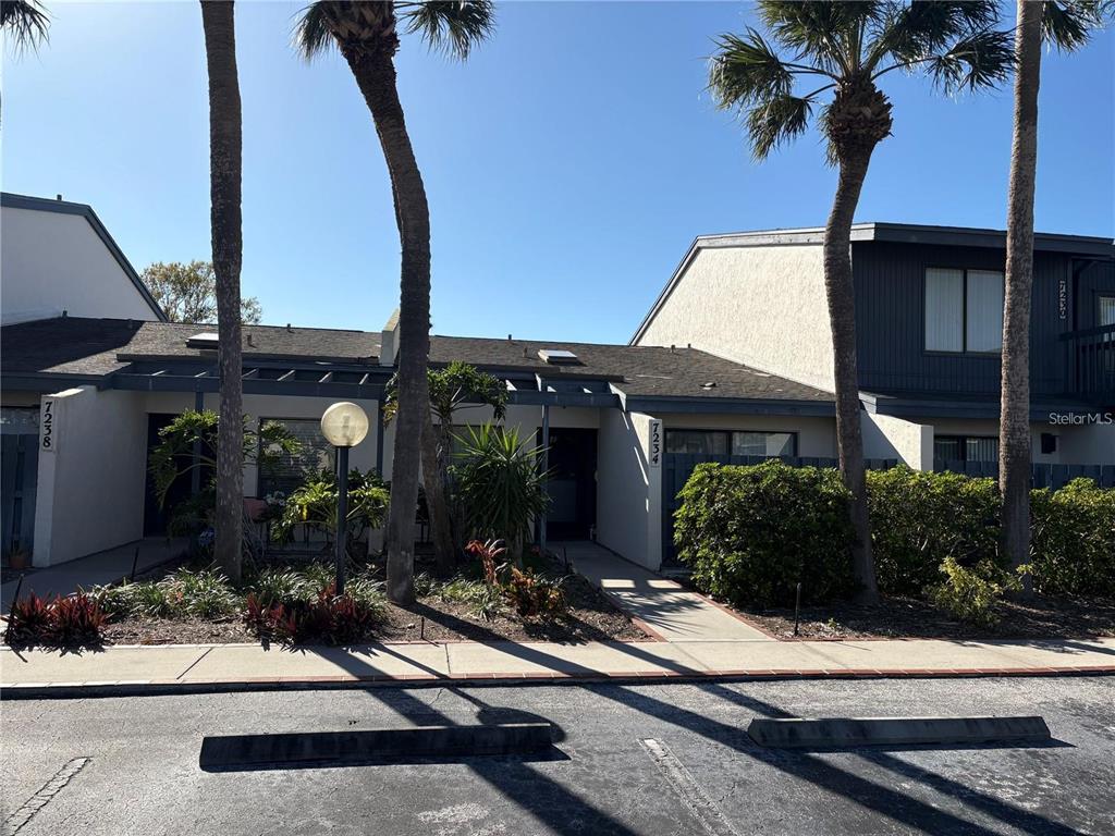A view of two adjacent residential units with palm trees and a sidewalk in front — 7234 CLOISTER DRIVE UNIT 7234, SARASOTA, FL