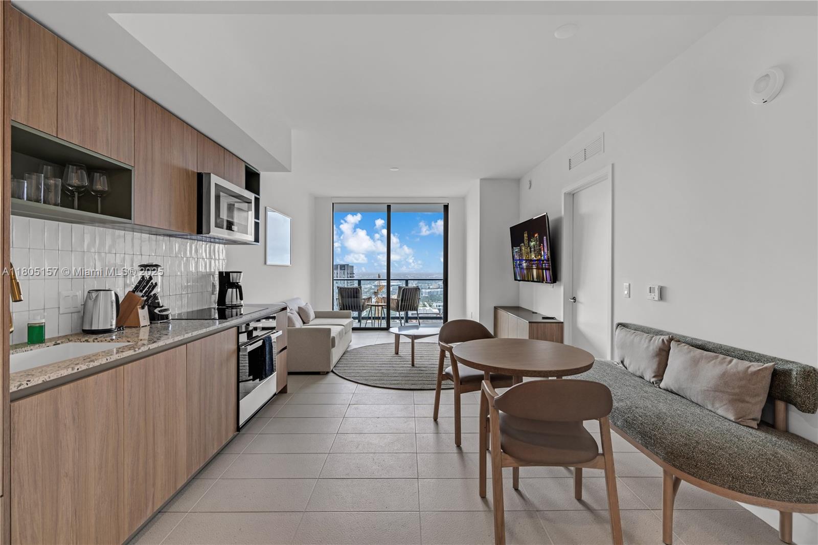 A modern studio apartment features a kitchen, dining area, and living space with balcony access — 601 NE 1st # 4204, Miami FL 33132, MIAMI, FL