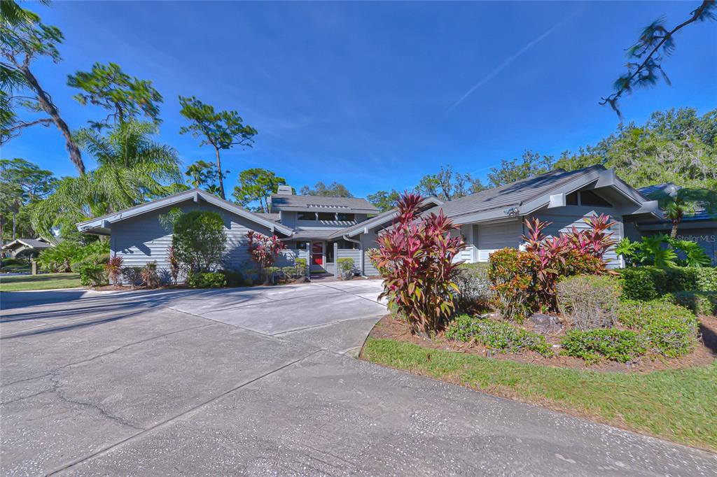 A gray, single-story house with a large concrete driveway and landscaped front yard — 5355 COBBLESTONE COURT, WESLEY CHAPEL, FL