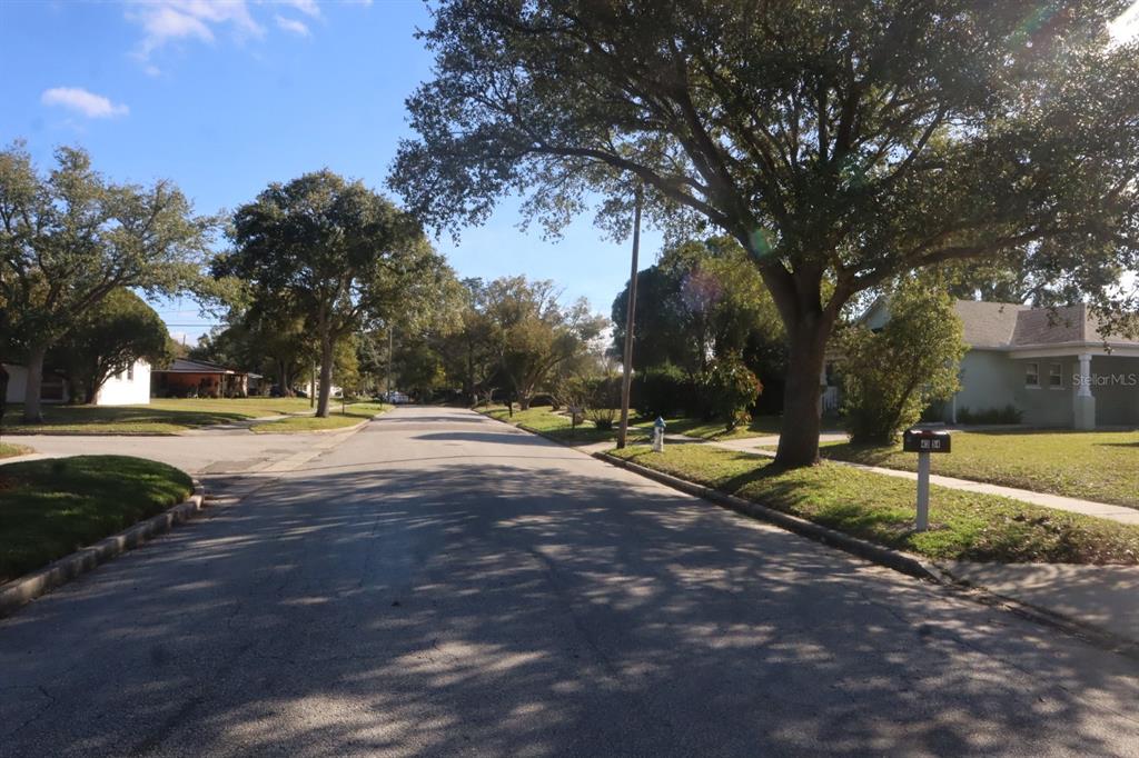 A quiet residential street lined with mature trees and houses under a clear blue sky — 4354 KIRKLAND BOULEVARD, ORLANDO, FL