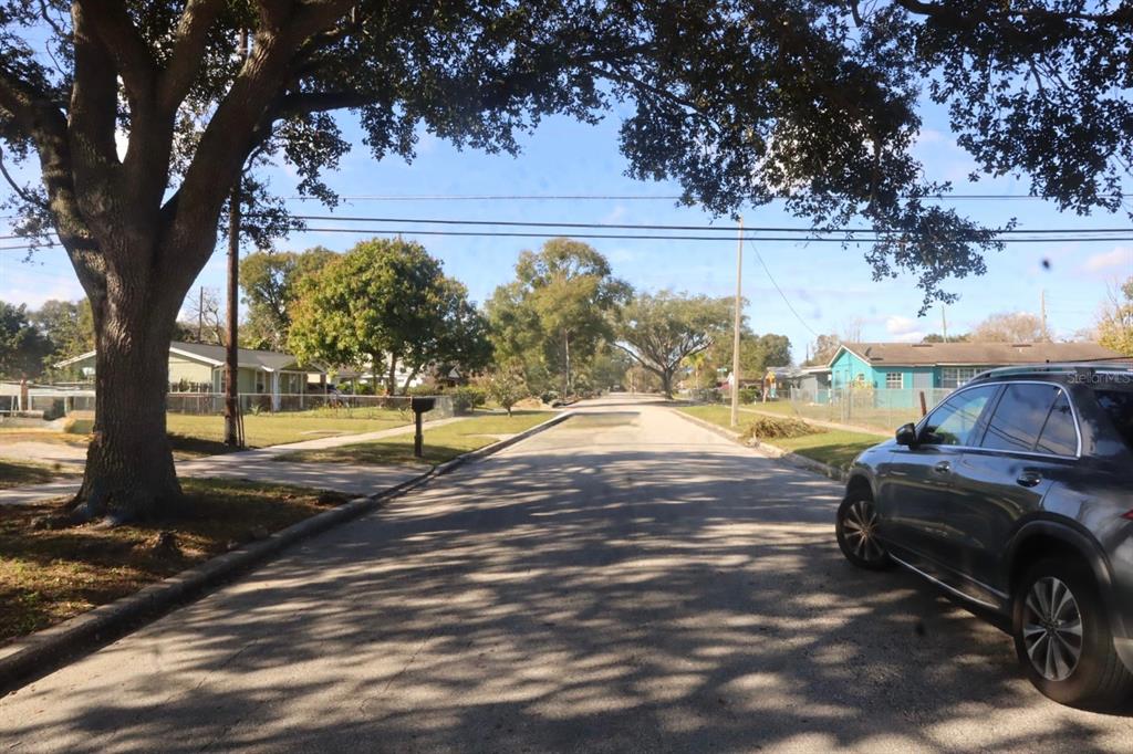 A residential street view featuring a large tree, a parked car, and nearby houses — 4354 KIRKLAND BOULEVARD, ORLANDO, FL