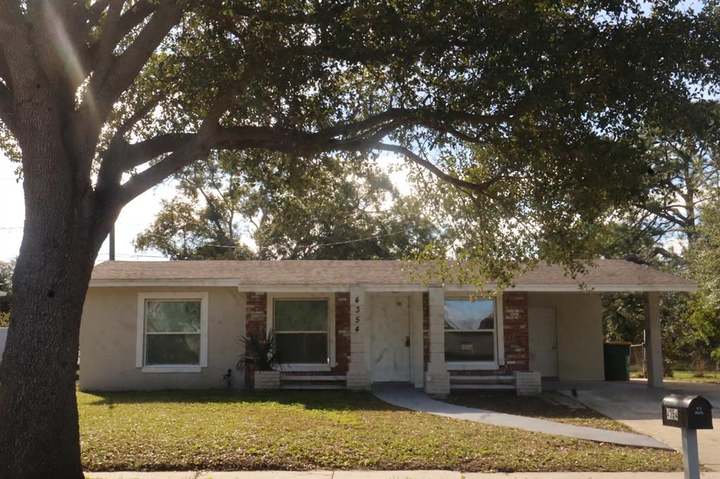 A single-story house with a carport, brick accents, and a large tree in the front yard — 4354 KIRKLAND BOULEVARD, ORLANDO, FL