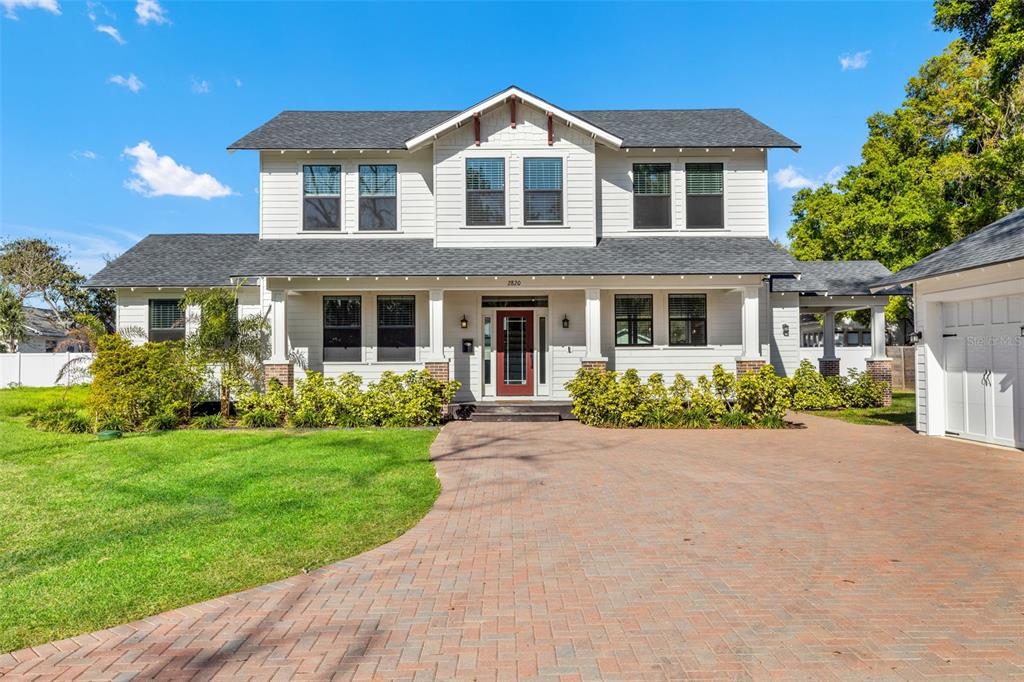 A two-story white house with a red front door and a brick driveway — 2820 N CENTRAL COURT, TAMPA, FL