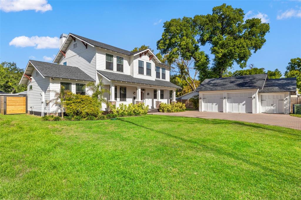 A two-story white house with a detached three-car garage and a large front lawn — 2820 N CENTRAL COURT, TAMPA, FL