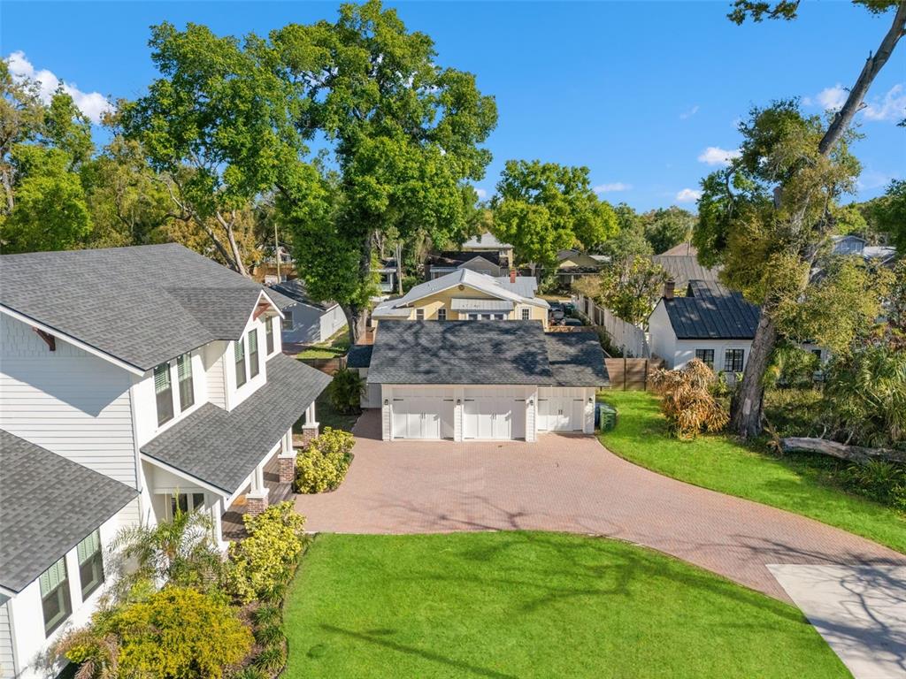 An aerial view shows a white house with a three-car garage and a brick driveway — 2820 N CENTRAL COURT, TAMPA, FL