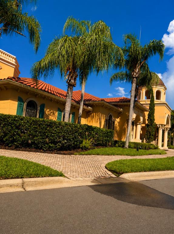 A yellow Mediterranean-style house with a red tile roof and palm trees in the front — 2717 VIA CIPRIANI UNIT 631A, CLEARWATER, FL