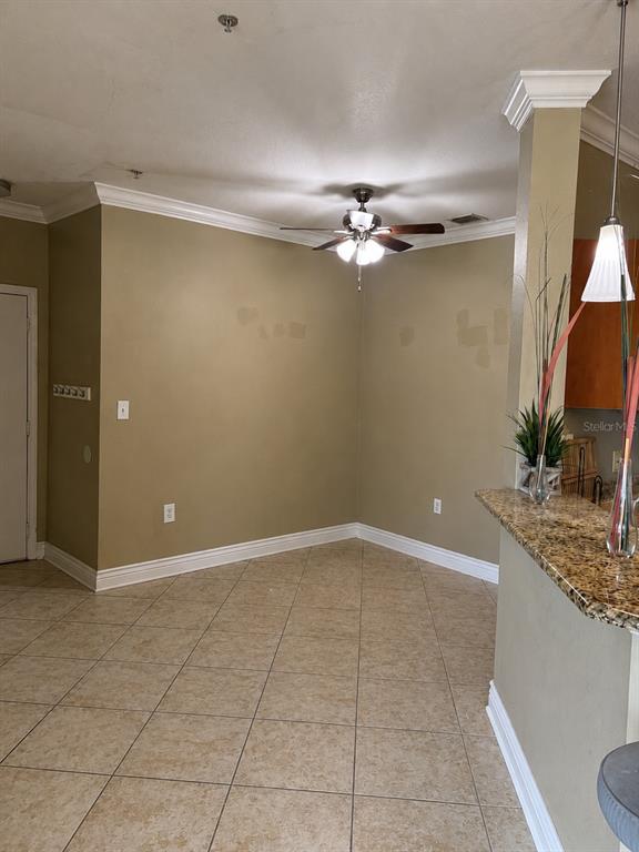 An empty dining area features tan walls, a ceiling fan, and light-colored tile flooring — 2717 VIA CIPRIANI UNIT 631A, CLEARWATER, FL