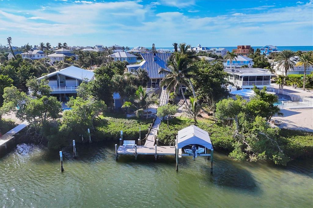 An aerial view shows a waterfront house with a private dock and boat lift — 30 GASPARILLA WAY, PLACIDA, FL