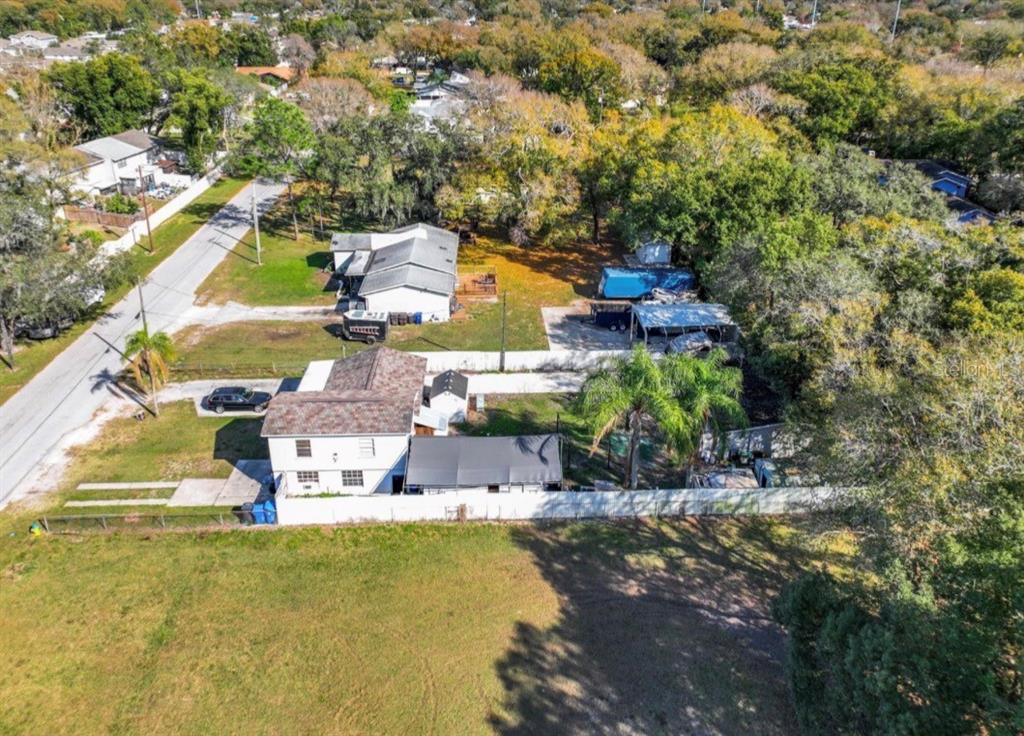 An aerial view shows a house with a white exterior, a brown roof, and a yard — 3408 RIVER COVE DRIVE, TAMPA, FL
