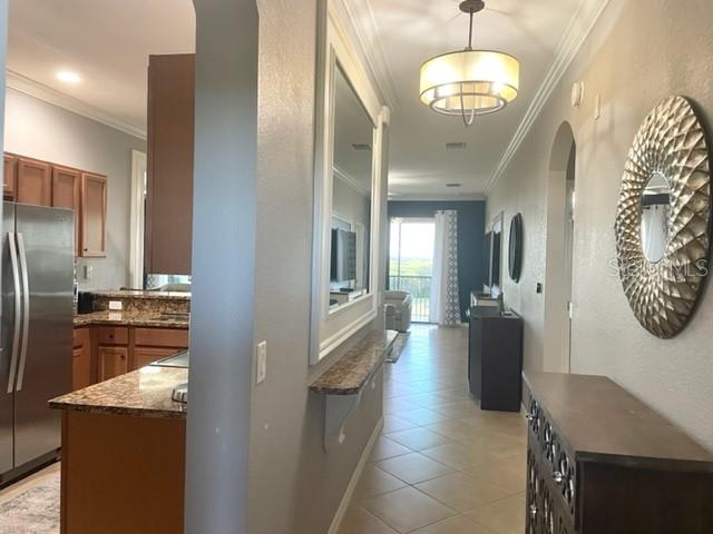 A hallway leads from a kitchen with granite countertops toward a living area with balcony views — 7019 RIVER HAMMOCK DRIVE UNIT 404, BRADENTON, FL