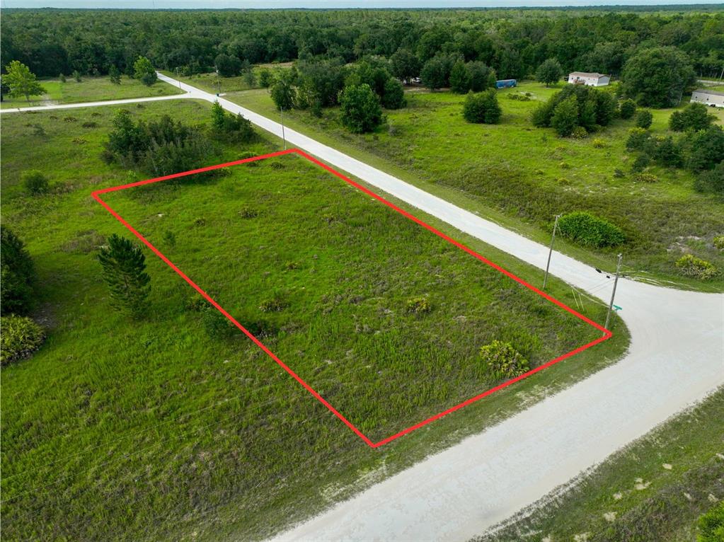 An aerial view shows a rectangular, grass-covered vacant lot bordered by dirt roads — 9017 SPLIT STONE DRIVE, WEBSTER, FL