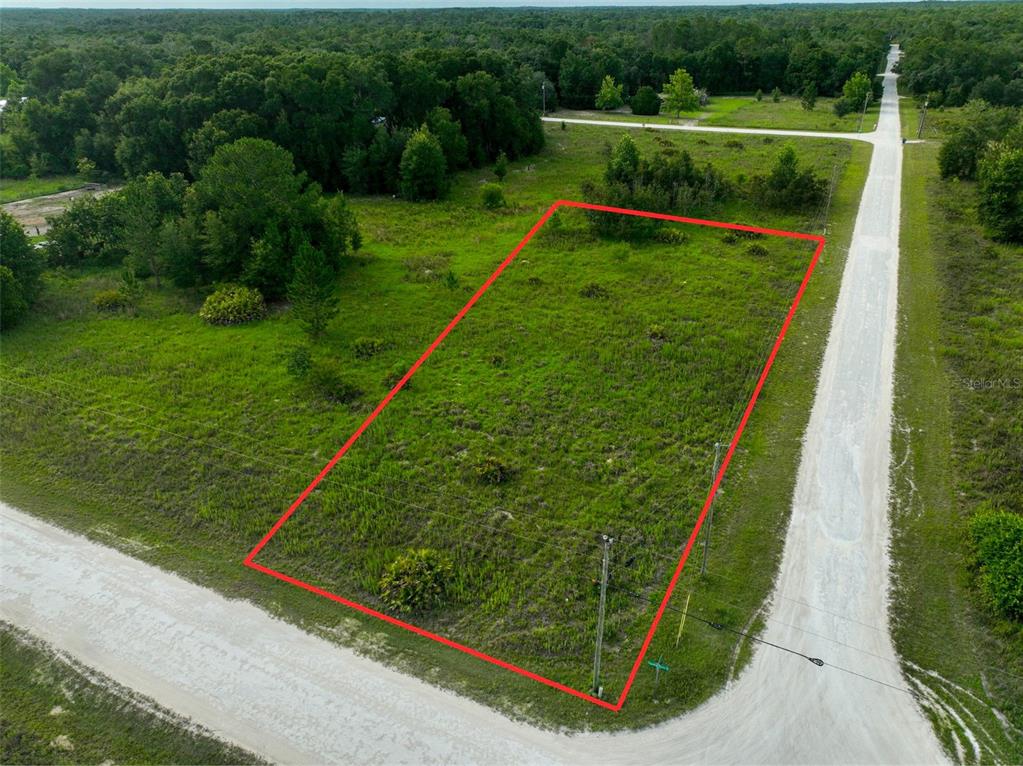 An aerial view shows a vacant, rectangular grassy lot outlined in red along a road — 9017 SPLIT STONE DRIVE, WEBSTER, FL
