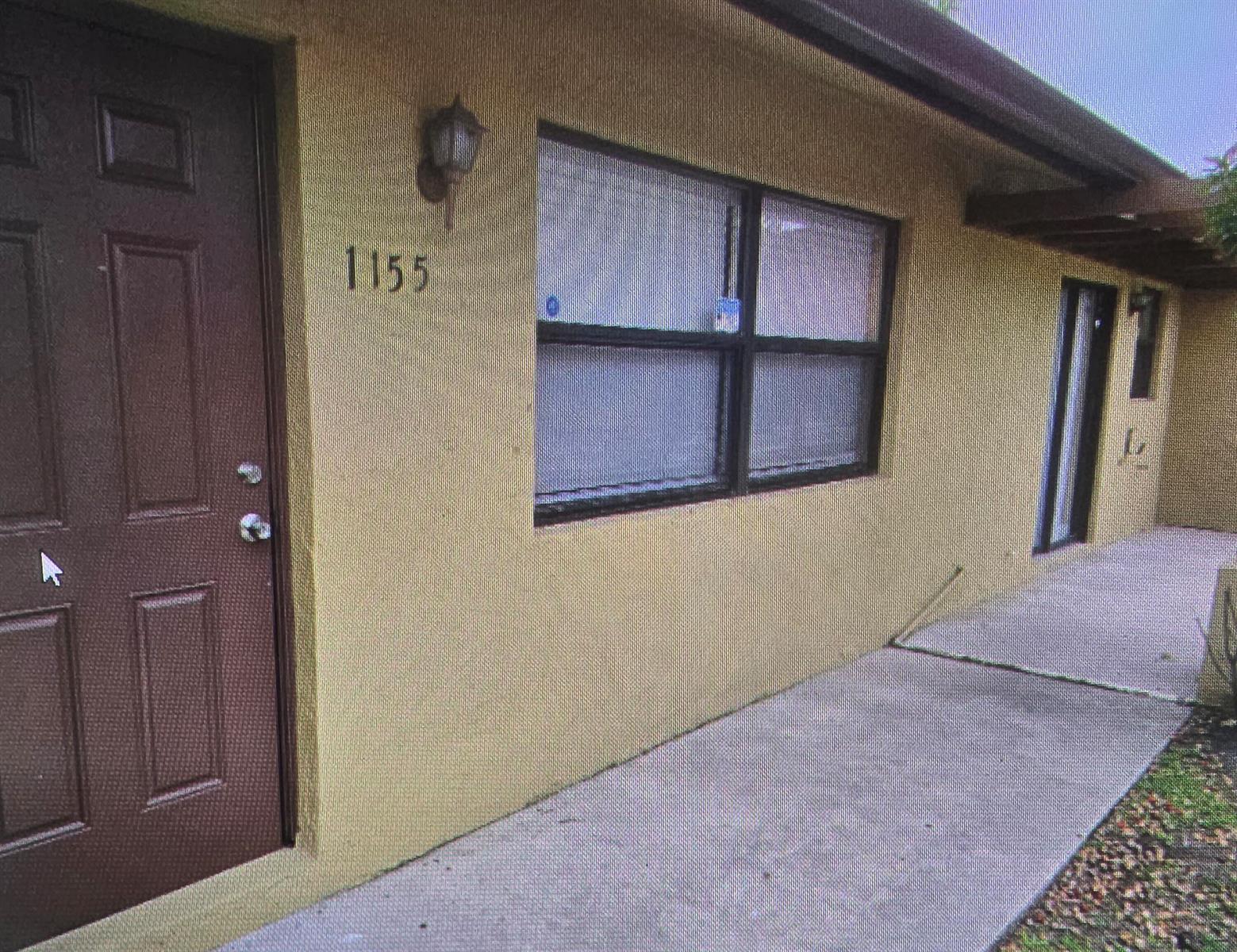 A brown door and a window are on the exterior wall of a tan building — 1155 White Pine Pine # 1155, Wellington FL 33414, WELLINGTON, FL
