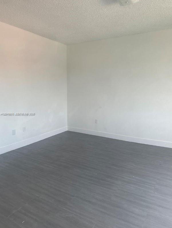 An empty room features white walls, gray wood-look flooring, and a white ceiling — 2961 SW 5th St # 21, Miami FL 33135, MIAMI, FL
