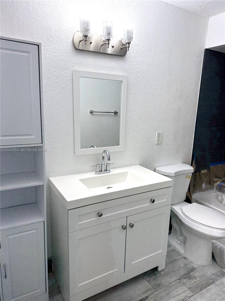 A bathroom features a white vanity with a sink, a mirror, and a toilet — 15560 SW 104th Ter # 619, Miami FL 33196, MIAMI, FL