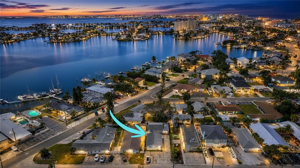 An aerial view shows a residential property with multiple buildings and parking spaces at dusk — 190 73RD AVENUE UNIT A, ST PETE BEACH, FL