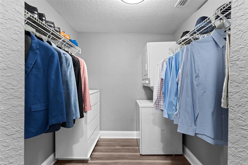 A walk-in closet features clothing racks, a white dresser, and a stacked washer and dryer — 1019 SUSAN DRIVE, LAKELAND, FL