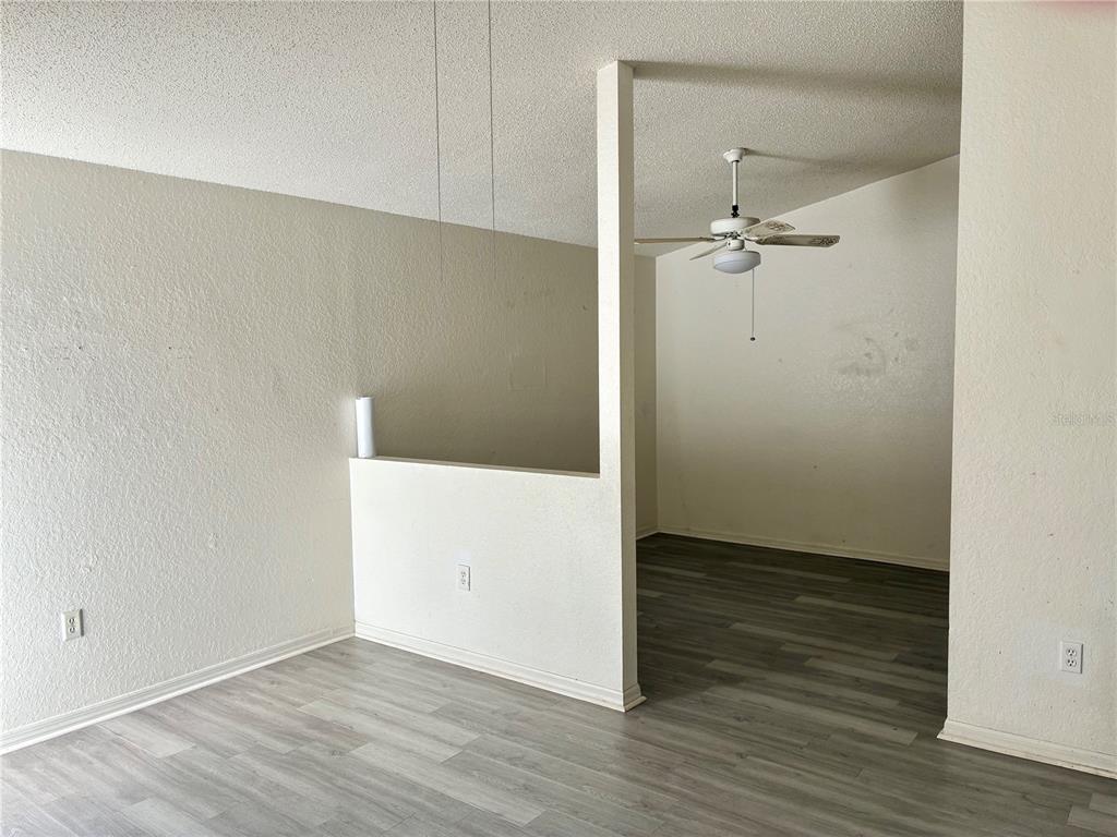 An interior view of a room with light-colored walls, wood-look flooring, and a ceiling fan — 4092 JASON ROAD, SPRING HILL, FL