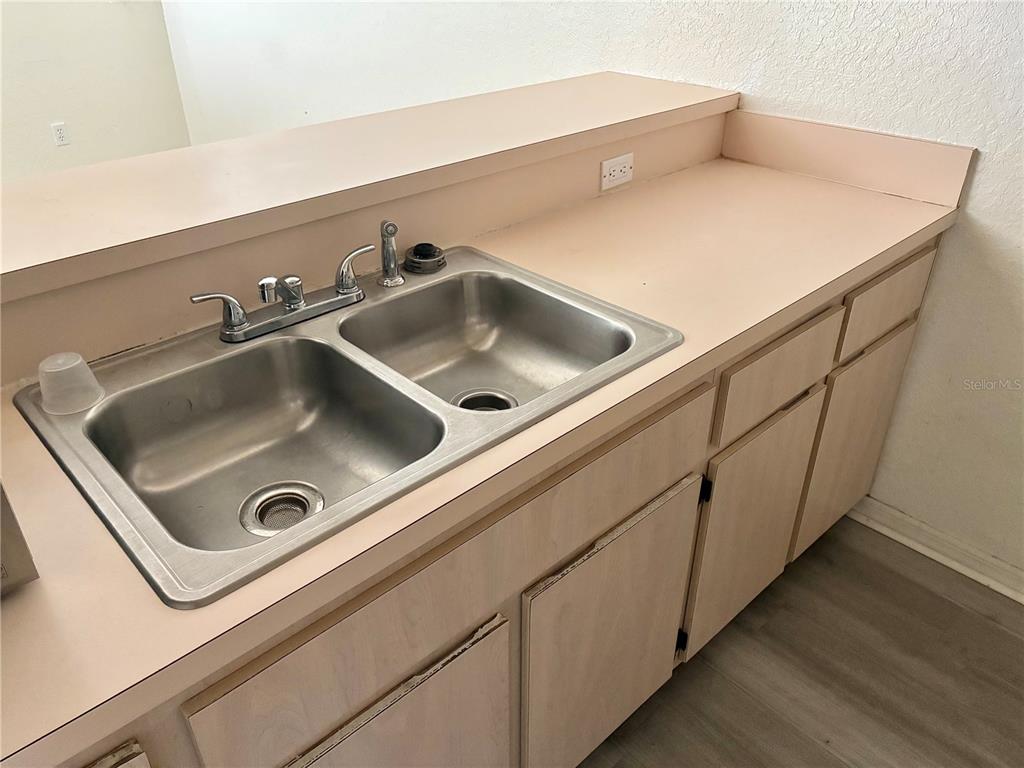 A kitchen sink with a faucet is set into a light-colored countertop with cabinets below — 4092 JASON ROAD, SPRING HILL, FL
