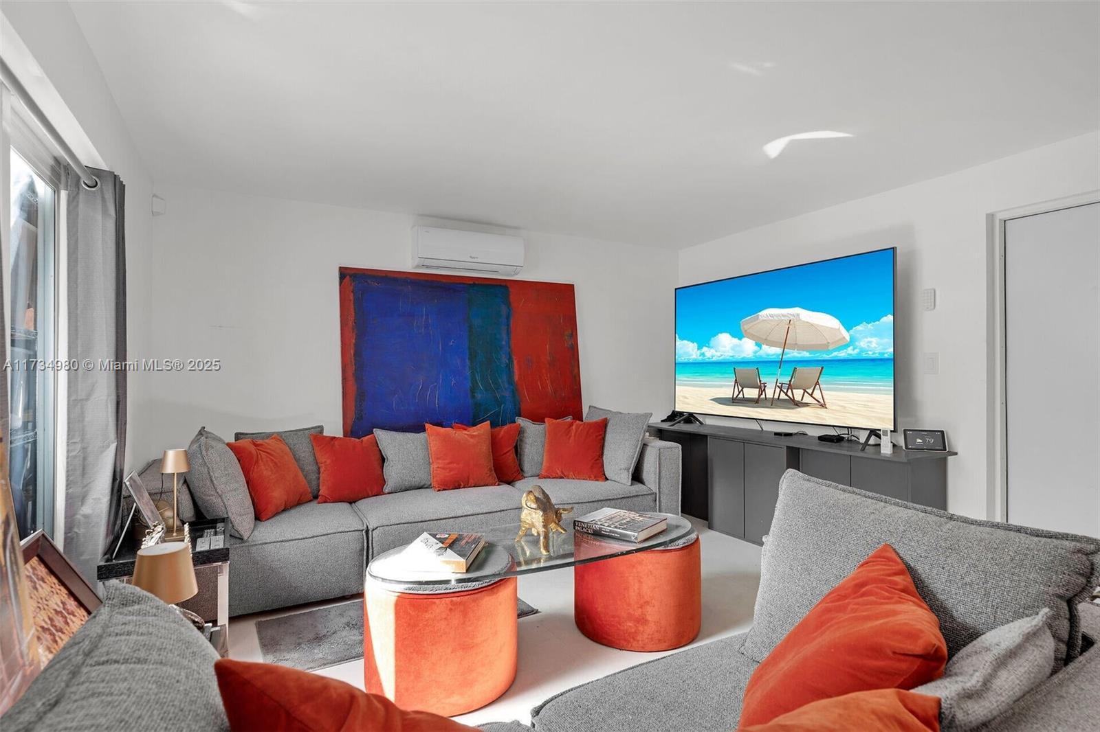 A living room features a grey sectional sofa, orange accent pillows, and a large television — 98703 Overseas Hwy, Key Largo FL 33037, KEY LARGO, FL