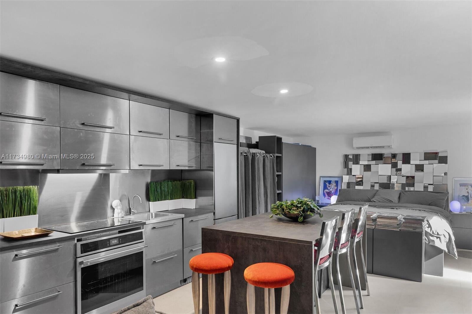 A modern studio apartment features a metallic kitchen, a central island, and a bed area — 98703 Overseas Hwy, Key Largo FL 33037, KEY LARGO, FL