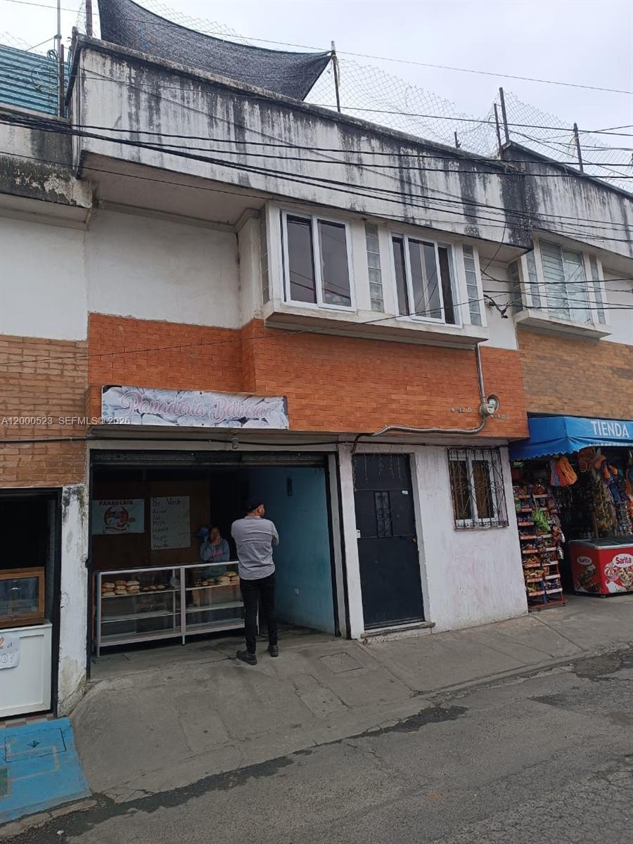 A two-story building features a ground-floor bakery storefront and an adjacent small shop — 9 calle NW 8-92 zona 11, MA 01057, MA