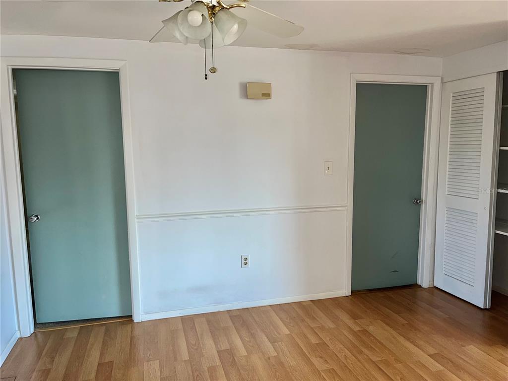 A room with light wood flooring, white walls, two teal doors, and a ceiling fan — 503 S VENICE BOULEVARD, VENICE, FL