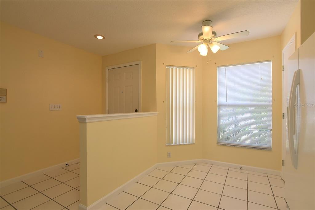 A kitchen dining area features yellow walls, white tile flooring, and a ceiling fan — 2203 CYPRESS KNEE LOOP, KISSIMMEE, FL