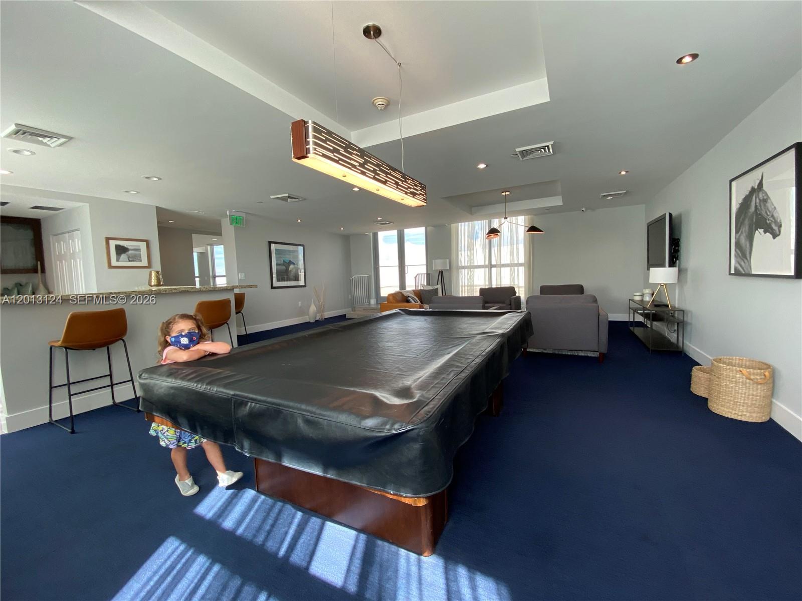 A spacious recreation room features a pool table, bar seating, and blue carpeting — 140 S Dixie Hwy # 1025, Hollywood FL 33020, HOLLYWOOD, FL