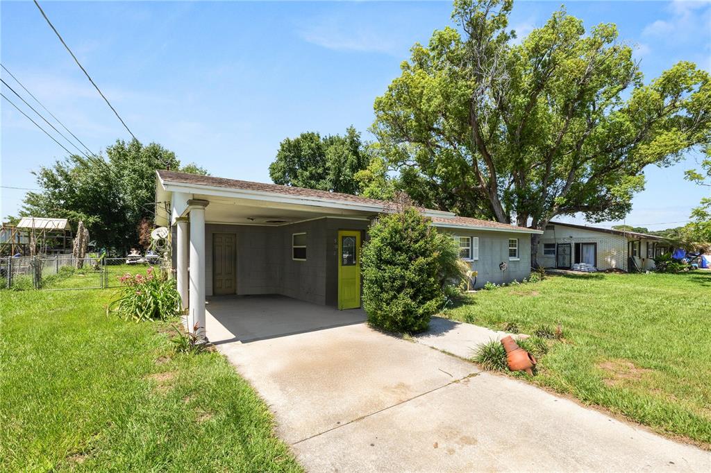 A single-story house with a concrete block exterior and a covered carport — 517 TANGLEWOOD DRIVE, AUBURNDALE, FL