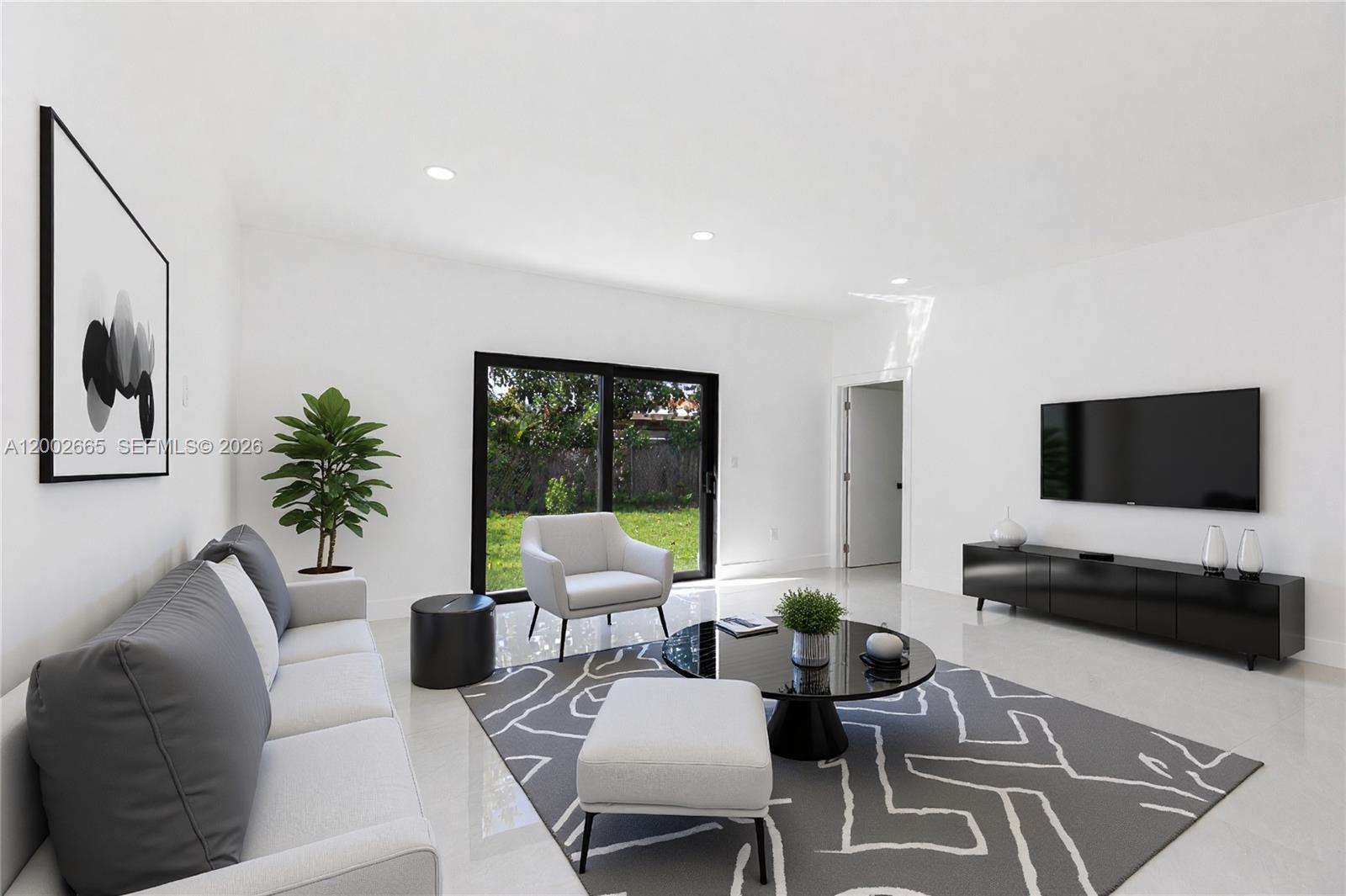 A modern living room features a grey sofa, a black coffee table, and a television — 5550 SW 4th St, Miami FL 33134, MIAMI, FL