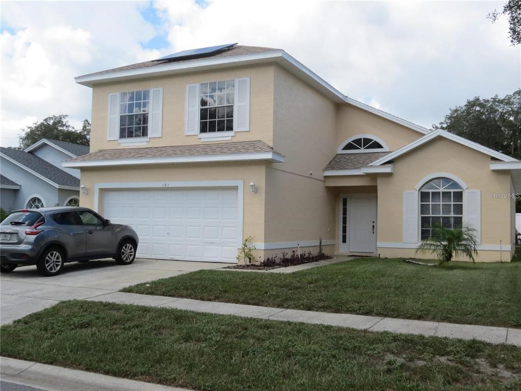 A swimming pool and spa are enclosed within a screened lanai at sunset — 151 PINEWOOD DRIVE, DAVENPORT, FL
