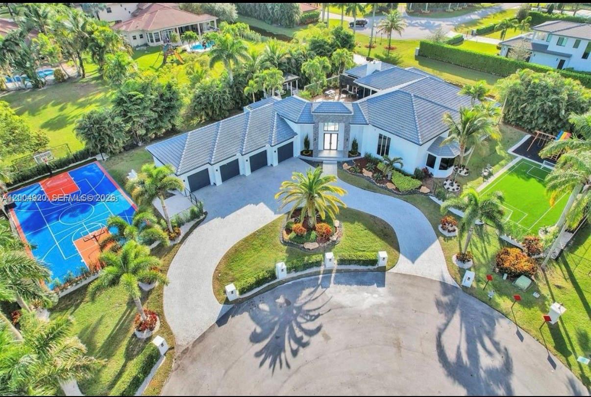 An aerial view of a house with a circular driveway, basketball court, and soccer field — 11400 NW 7th St, Plantation FL 33325, PLANTATION, FL