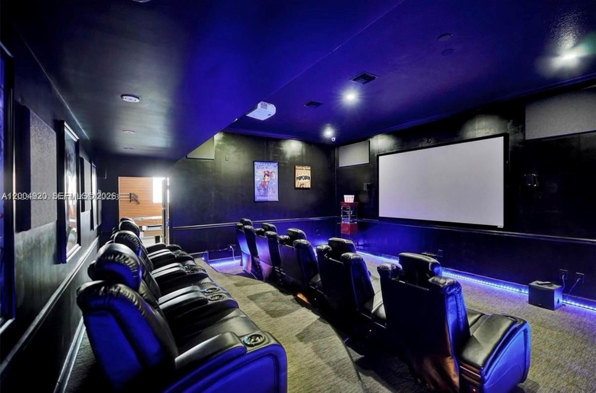 A home theater room features tiered rows of black leather reclining seats and a projection screen — 11400 NW 7th St, Plantation FL 33325, PLANTATION, FL