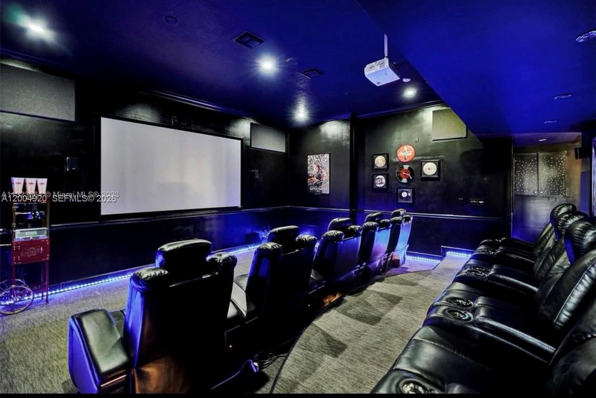 A home theater room features tiered rows of black leather recliners and a large projection screen — 11400 NW 7th St, Plantation FL 33325, PLANTATION, FL