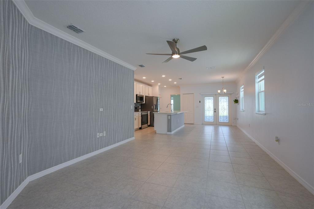 An open-concept living and kitchen area features tile flooring, a textured accent wall, and recessed lighting — 173 VILLAVISTA COURT, DAVENPORT, FL