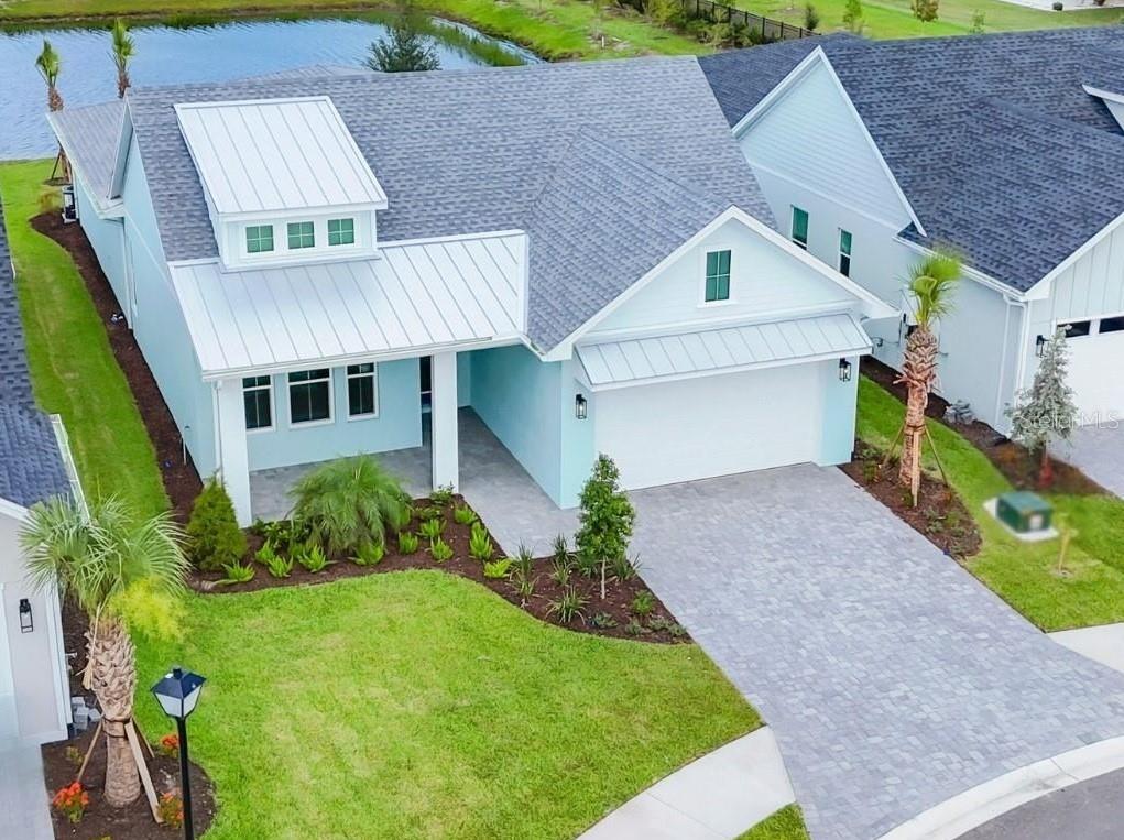 A light blue single-story house features a white garage, a palm tree, and landscaped lawn — 705 ANEGADA LANE, SARASOTA, FL