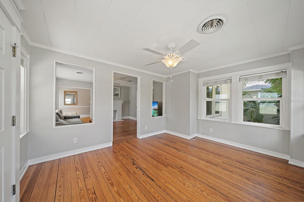 A living room with hardwood floors, a ceiling fan, and two interior wall cutouts — 2250 ARLINGTON STREET, SARASOTA, FL