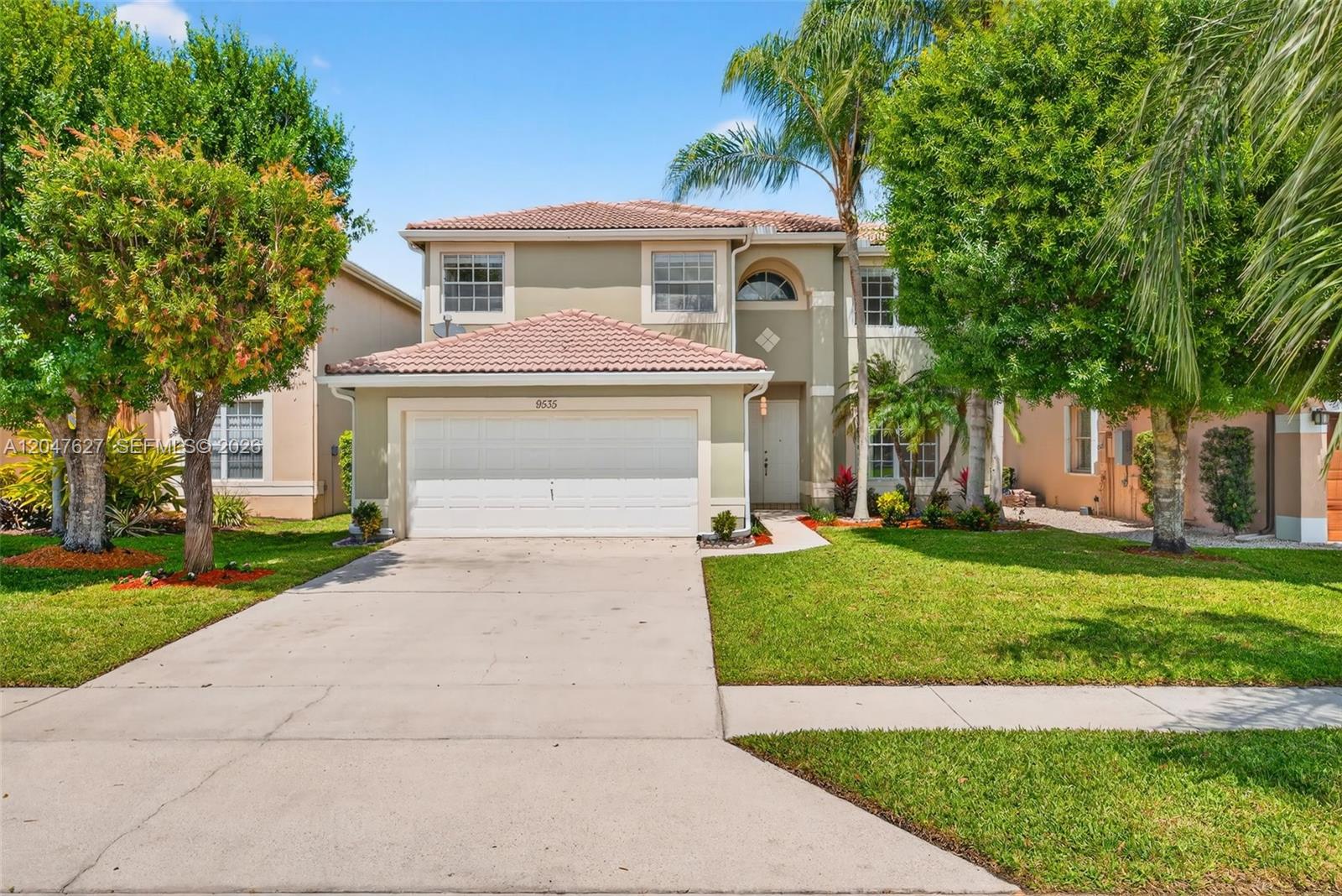 A two-story suburban house with a white garage door, palm trees, and a concrete driveway — 9535 Fox Trot Ln, Boca Raton FL 33496, BOCA RATON, FL