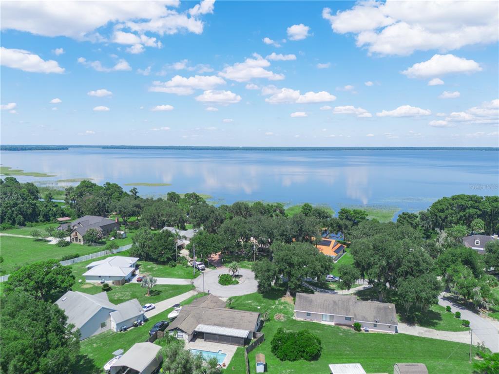A single-story brick and stucco house with a metal roof and two-car garage — 3038 SHADY WOOD LANE, LAKE WALES, FL